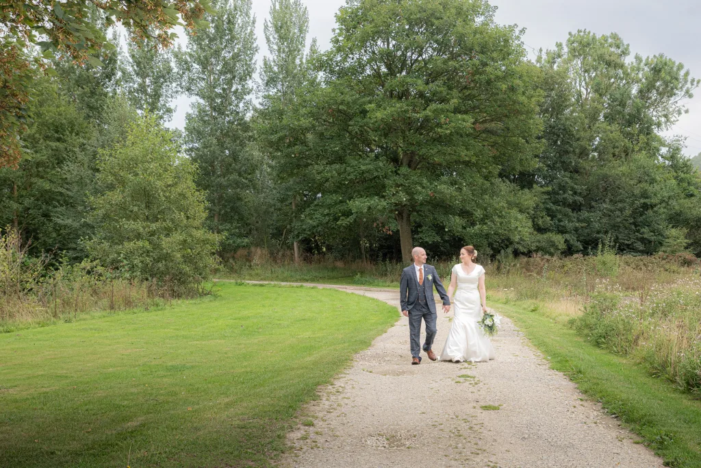 Bride and groom take at stroll and are captured by wedding photographer at Hackness Grange.