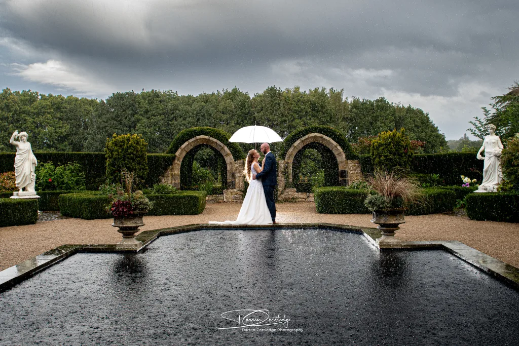Bride and Groom embrace in the rain at North Yorkshire wedding.