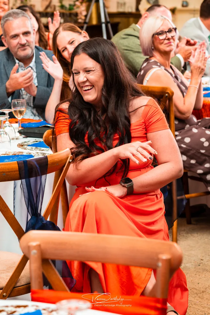 Bridesmaid laughing hysterically during a wedding speech at a barn wedding in Yorkshire