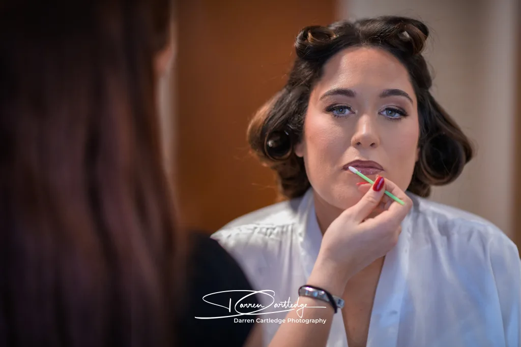Make-up artist applying finishing touches to the bride during morning prep at a Yorkshire wedding
