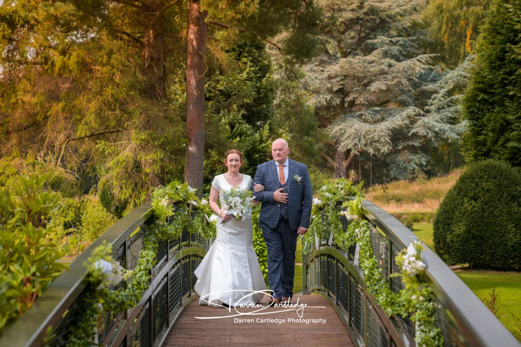 Bride arriving arm in arm with her father at Hackness Grange for a Yorkshire wedding