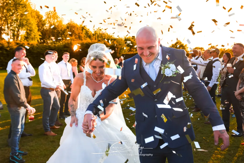 Bride and groom celebrating with confetti cannons during a Yorkshire wedding