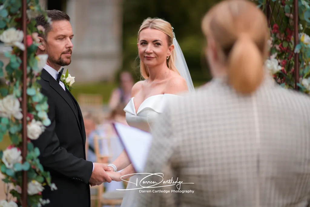 Bride and groom holding hands during their wedding ceremony at a Yorkshire wedding