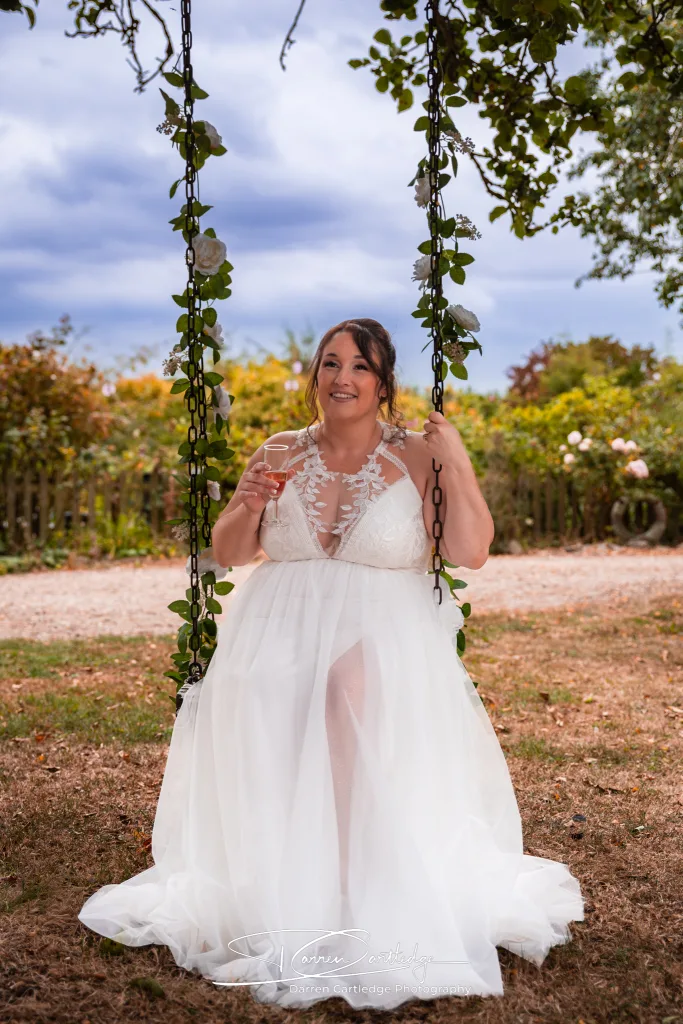 Bride sitting on a swing at Clapham Holme Farm during an East Yorkshire wedding