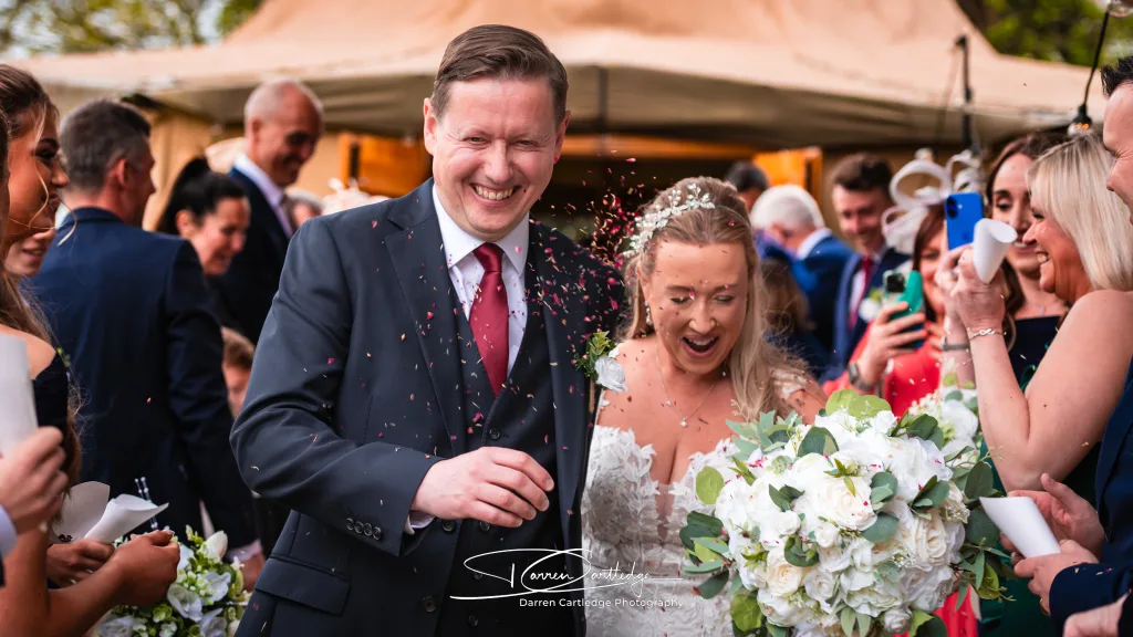 Groom leading the bride through confetti at Cedar Court Harrogate wedding in Yorkshire