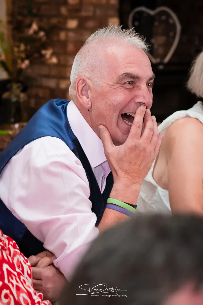 Guest laughing during a wedding speech at Clapham Holme Farm barn wedding in Yorkshire