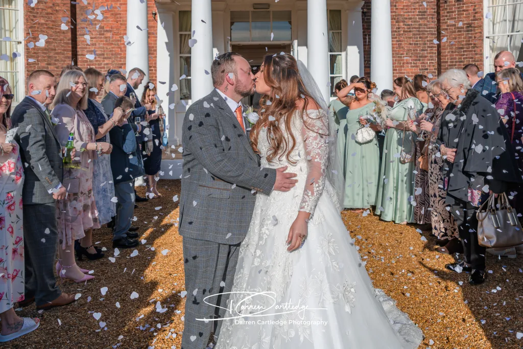 Bride and groom sharing a kiss in confetti at Bawtry Hall during a Yorkshire wedding