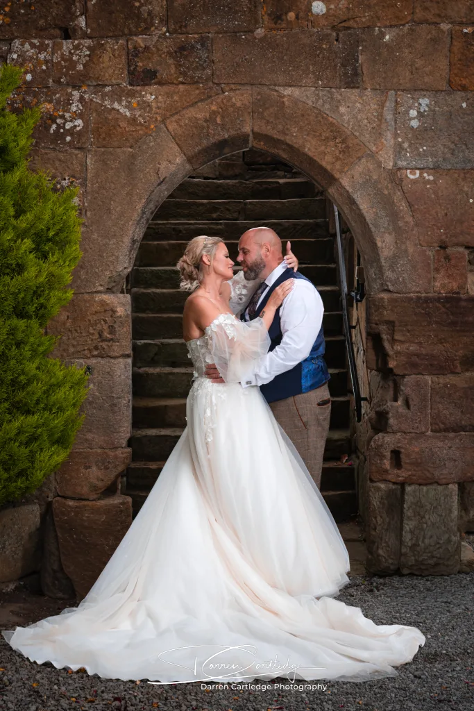 Bride and groom embracing in the barn at Danby Castle during a Yorkshire wedding