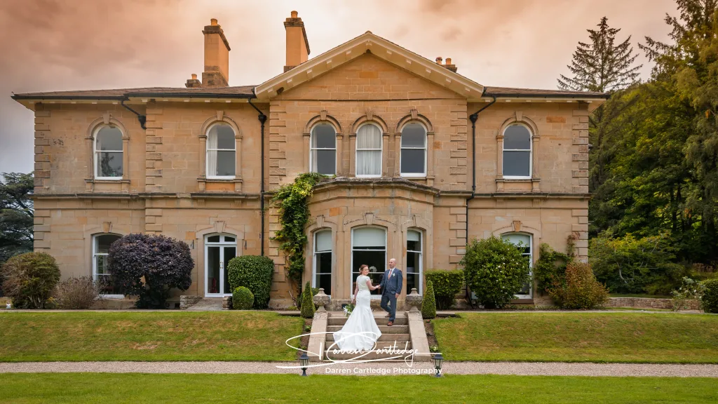 Bride and groom standing on the steps at Hackness Grange during a Yorkshire wedding