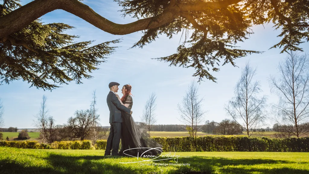 Bride and groom standing under the iconic tree at Hazlewood Castle during a Yorkshire wedding