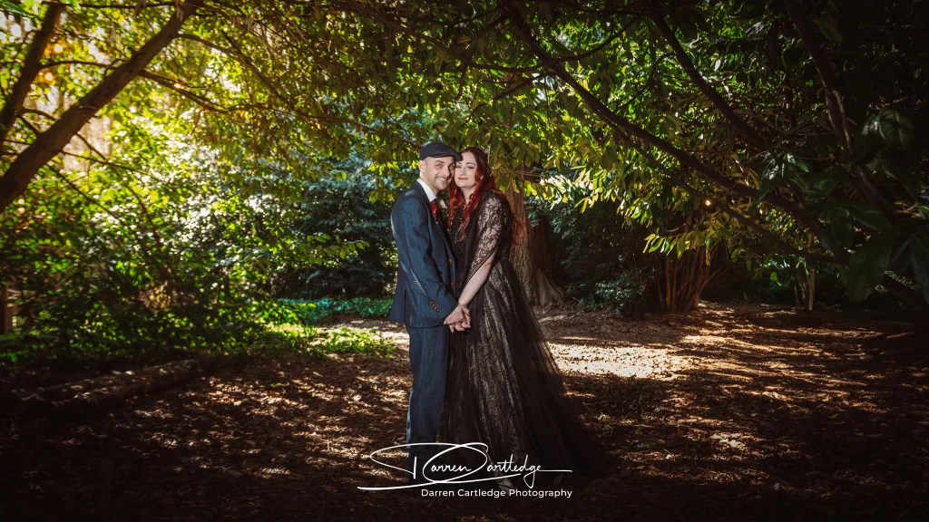 Bride and groom standing under trees at Hazlewood Castle during a Yorkshire wedding