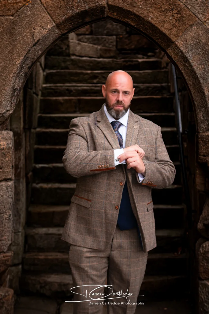 Groom making final adjustments before the ceremony at Danby Castle, Yorkshire