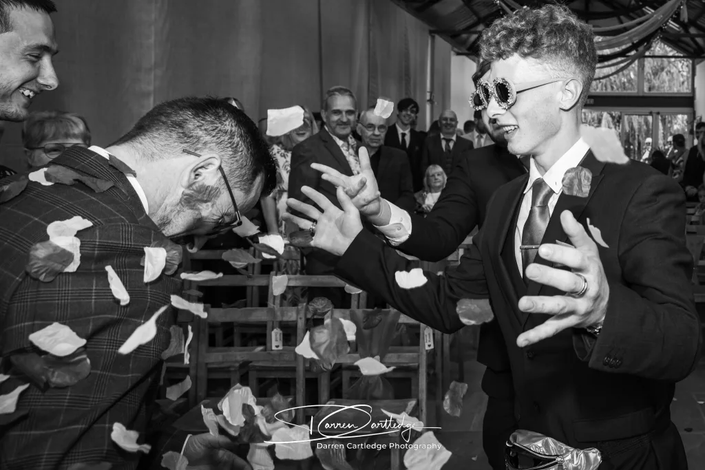 Flower man throwing petals over the groom during a Yorkshire wedding ceremony