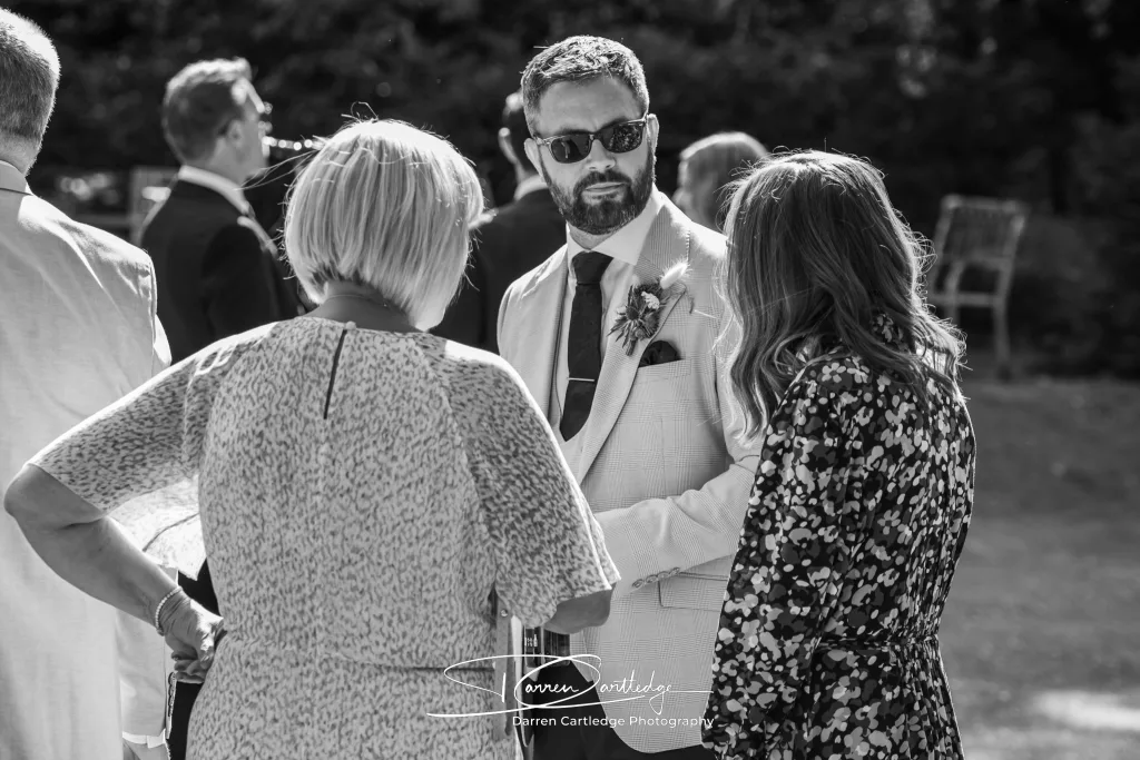 Groom chatting with wedding guests at The Old Deanery in Ripon during a Yorkshire wedding
