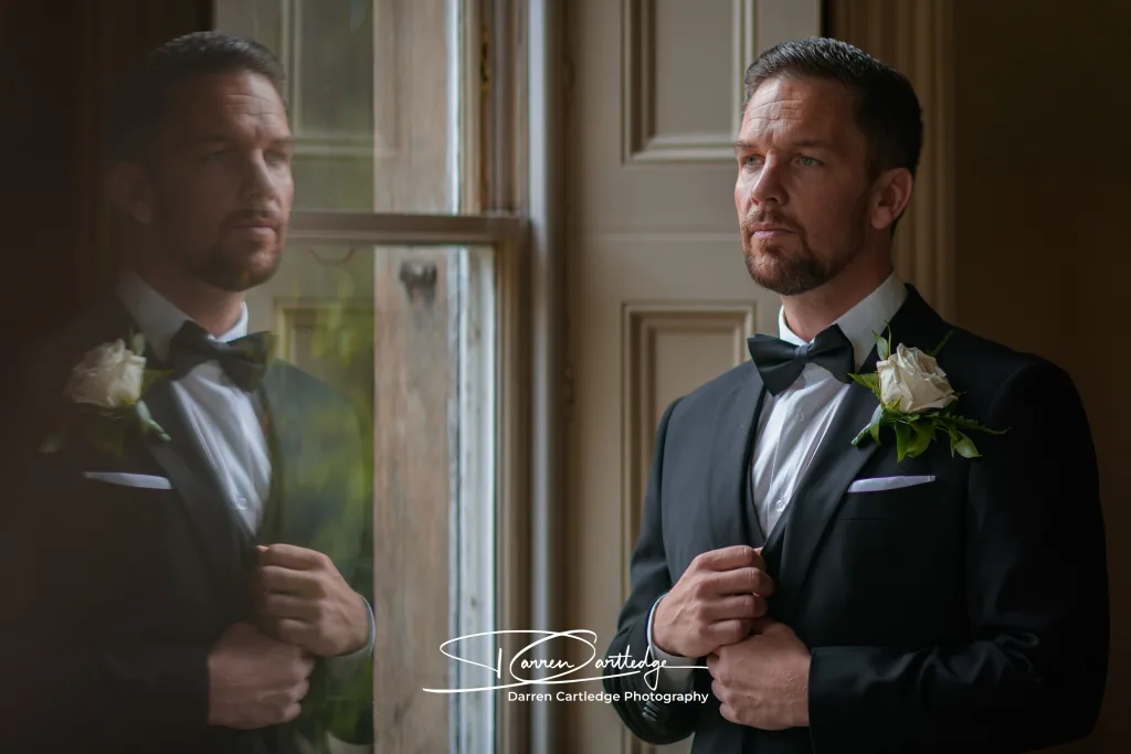 Portrait of groom during final preparations with window reflection at a Yorkshire wedding