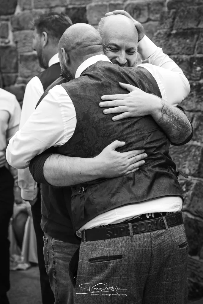 Groom greeting an old friend in an emotional moment during a Yorkshire wedding