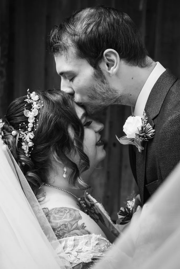 Groom kissing the bride on the forehead during a Yorkshire wedding