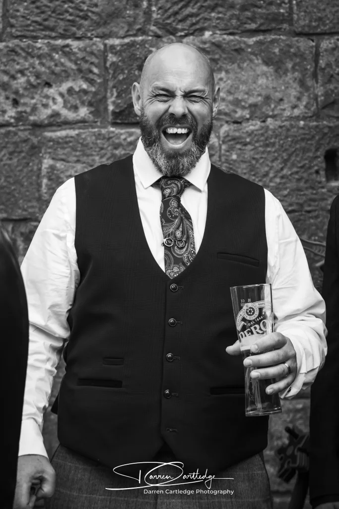 Groom laughing at Danby Castle during a Yorkshire wedding