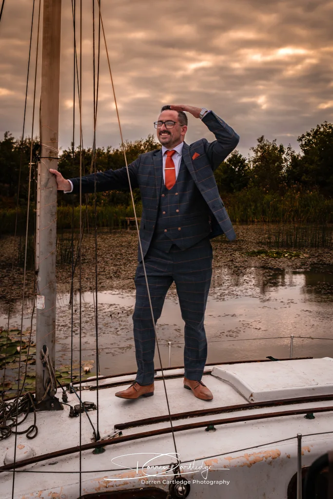 Groom on a boat at Clapham Holme Farm during a Yorkshire wedding