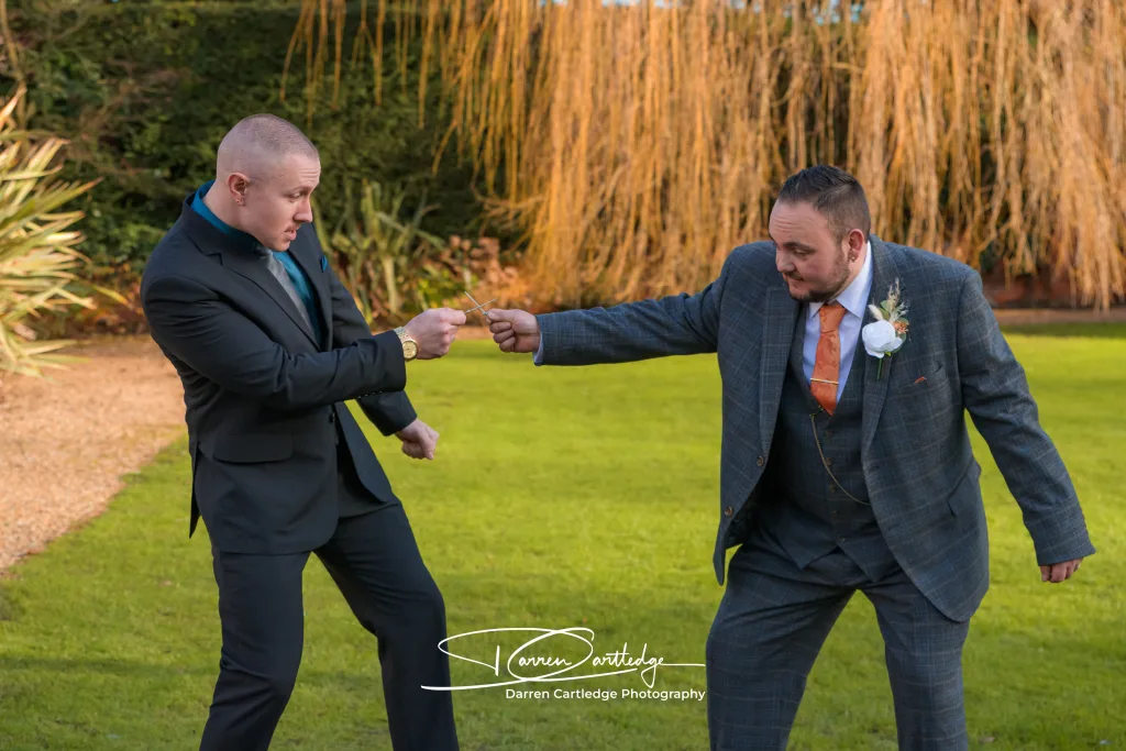 Groom having a playful sword fight at Bawtry Hall during a Yorkshire wedding