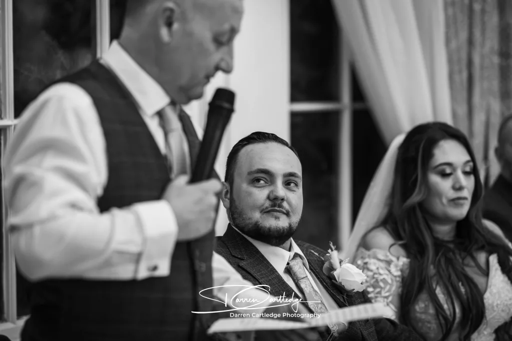 Groom watching as his father gives a speech at Bawtry Hall during a Yorkshire wedding
