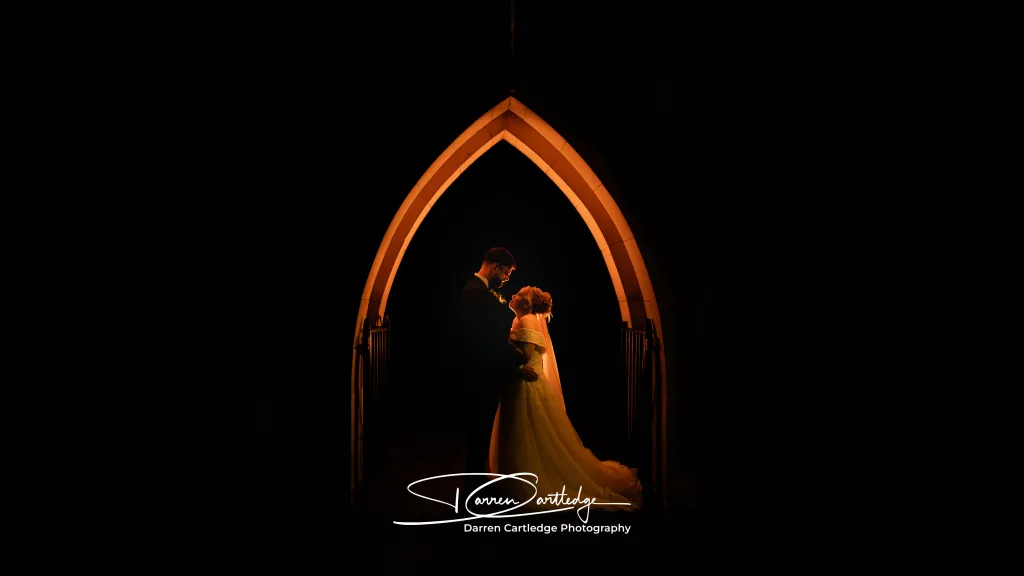 Couple under an arch at twilight during a wedding in Lincolnshire