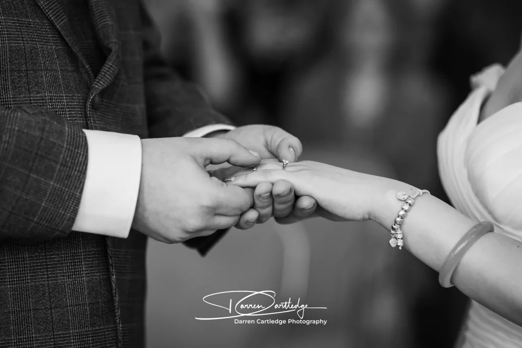 Groom delicately placing the wedding ring on the bride’s finger at a Yorkshire wedding