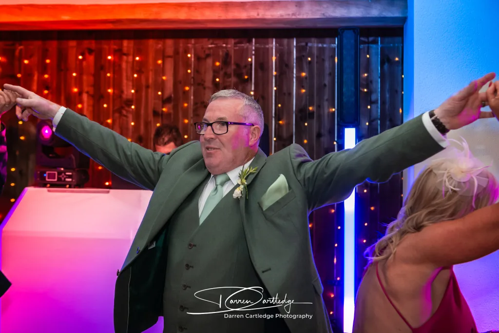 Wedding guests with hands in the air on the dancefloor during a Yorkshire wedding