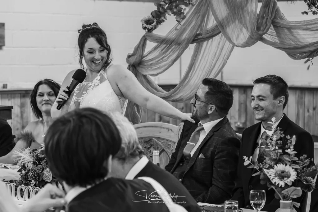 Bride playfully mocking the groom during speeches at Clapham Holme Farm wedding in Yorkshire